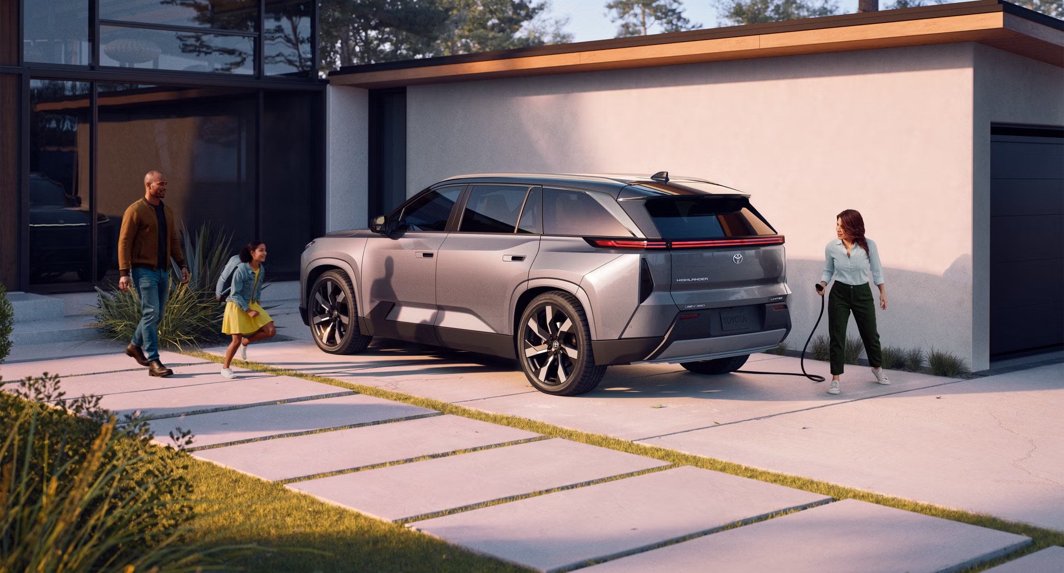 Family walking toward a Toyota SUV parked in the driveway of their home